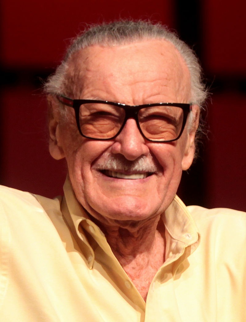 Stan Lee wearing a yellow shirt and spectacles