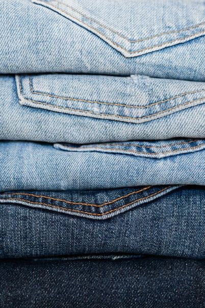 A Picture Displaying Stack of Jeans Arranged by Color.