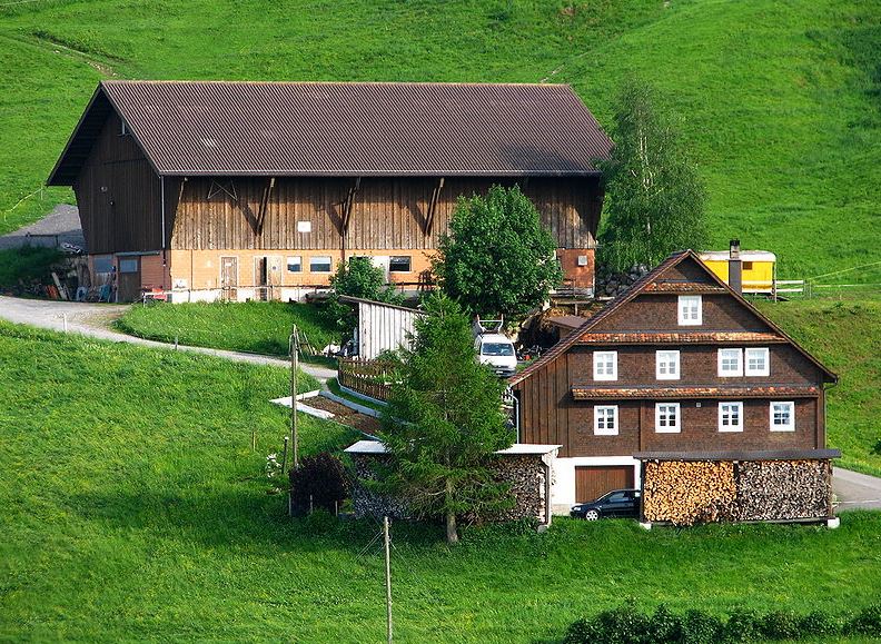 a farmhouse exterior and the wide green field