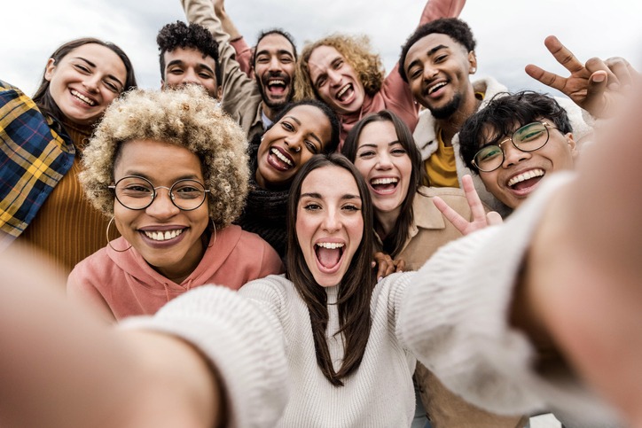 Multiracial friends taking big group selfie shot smiling at camera - Laughing young people standing outdoor and having fun - Cheerful students portrait outside school - Human resources concept