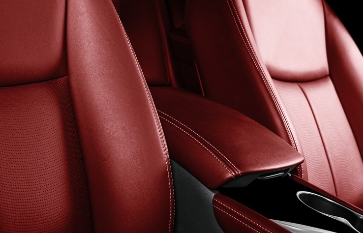Luxury car red leather interior. Part of leather car seat details with stitching. Comfortable perforated red leather seats. Red perforated leather. Car inside