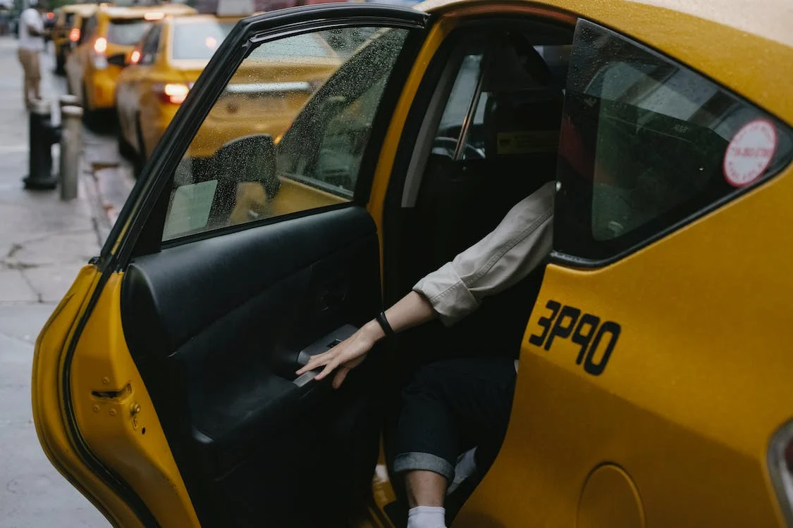 A person getting into a cab parked behind a line of other cabs