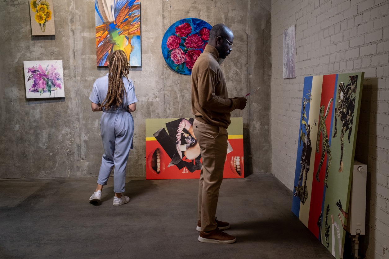 African man with leaflet standing in front of creative artwork