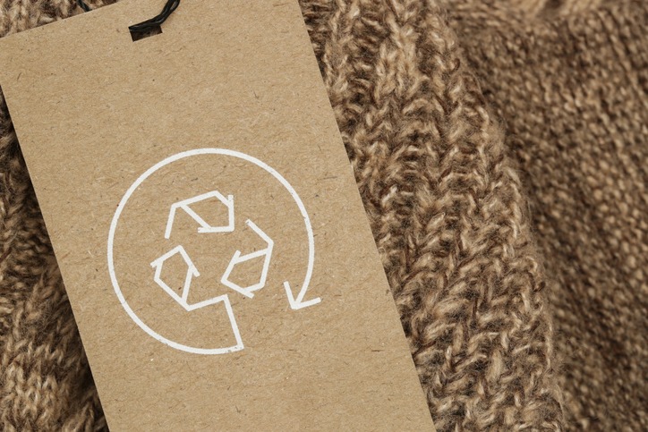 Close up of clothing tag with recycle icon. Recycling products concept. Zero waste, suistainale production, environment care and reuse concept