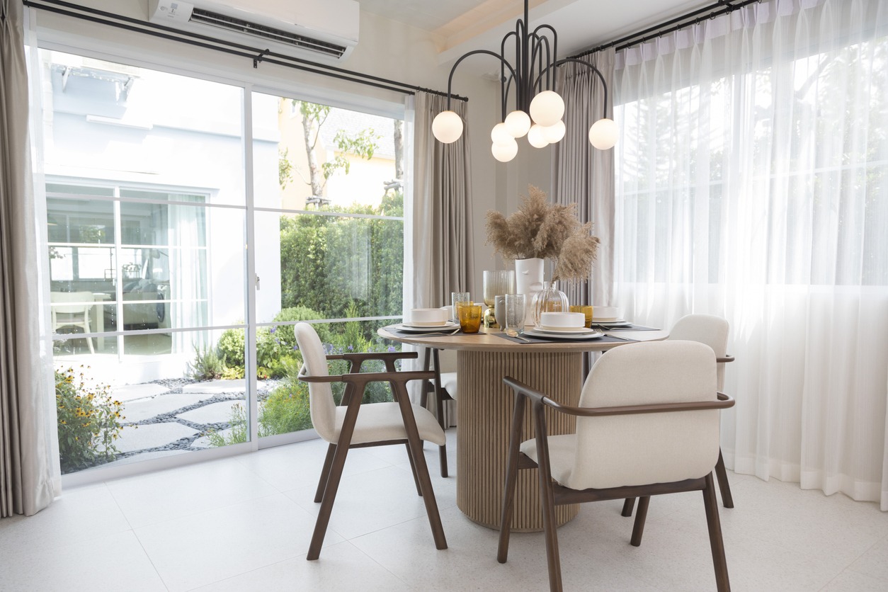 Dining table and chairs sitting by patio doors in a modern home