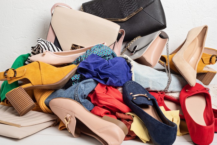 Fast fashion background with pile of cheap, low quality clothes