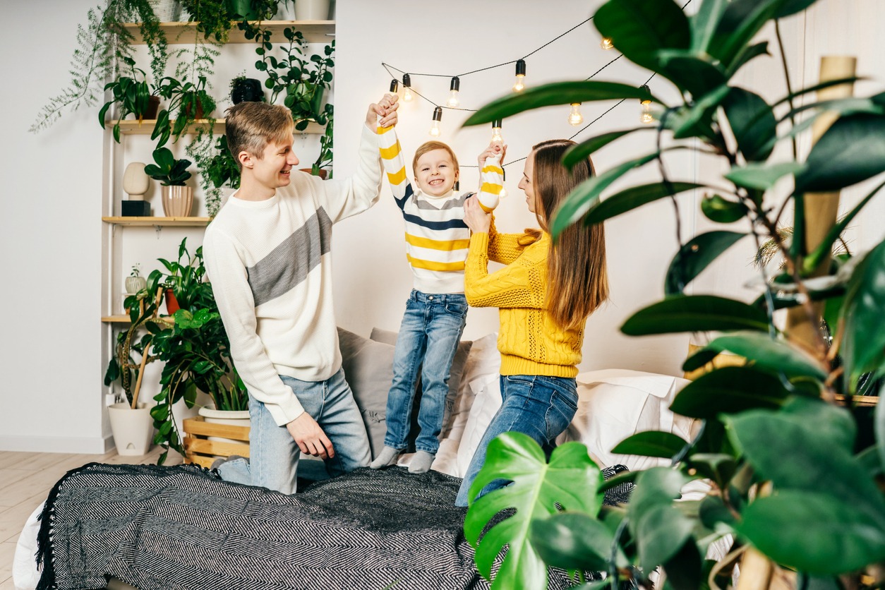 Happy family having fun at home with green houseplants around
