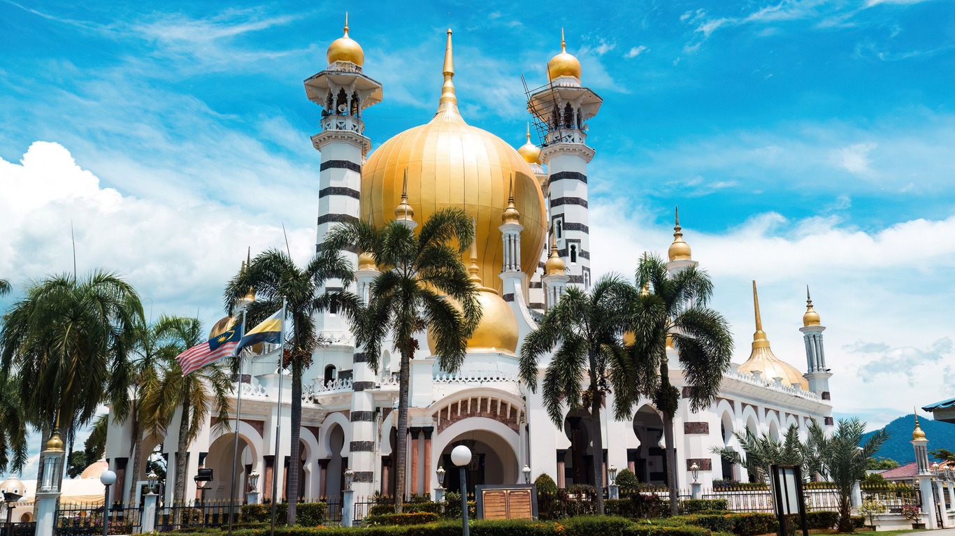 mosque with golden dome and Malaysian flag