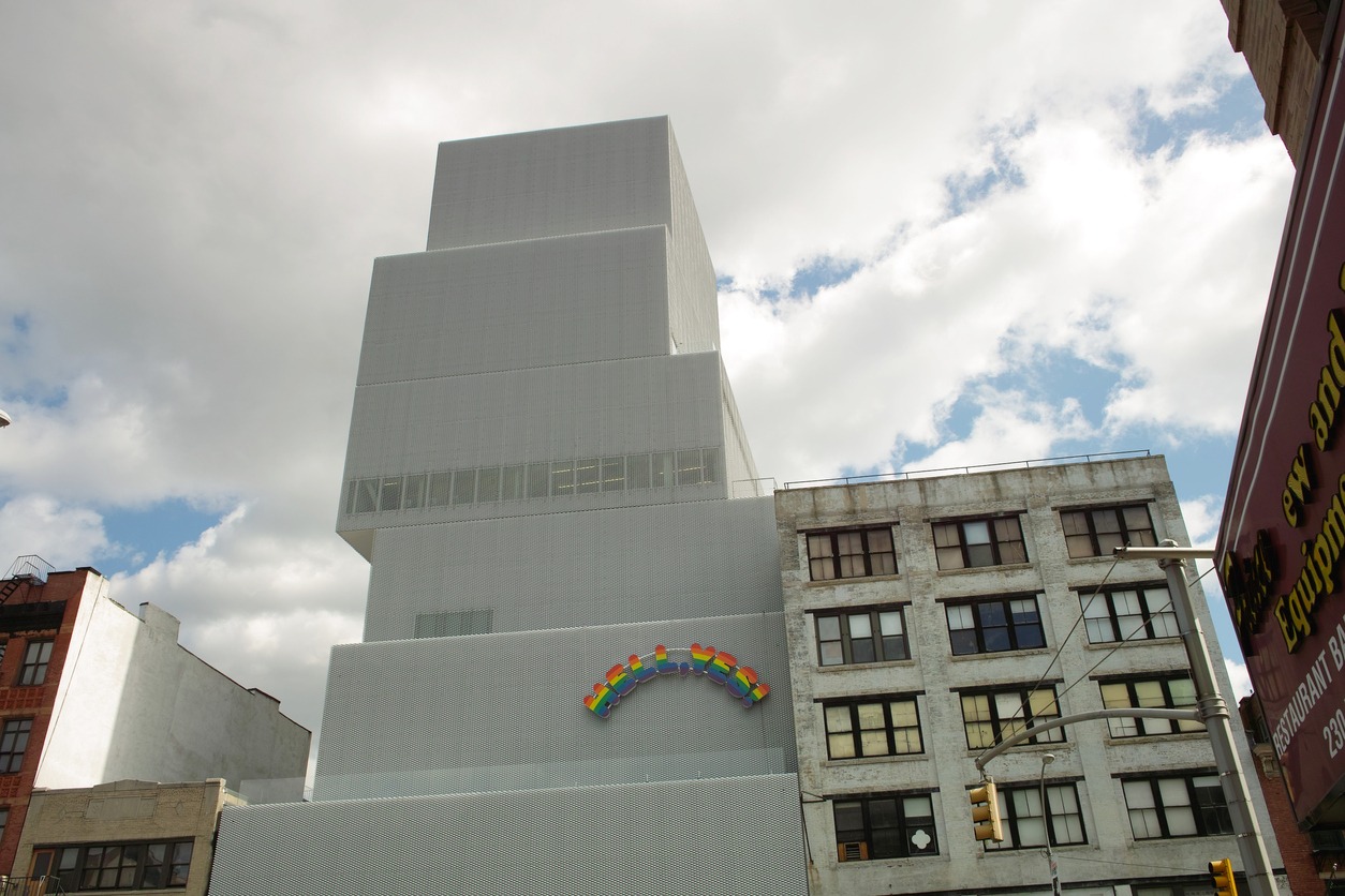 tall white building with a rainbow-colored signage