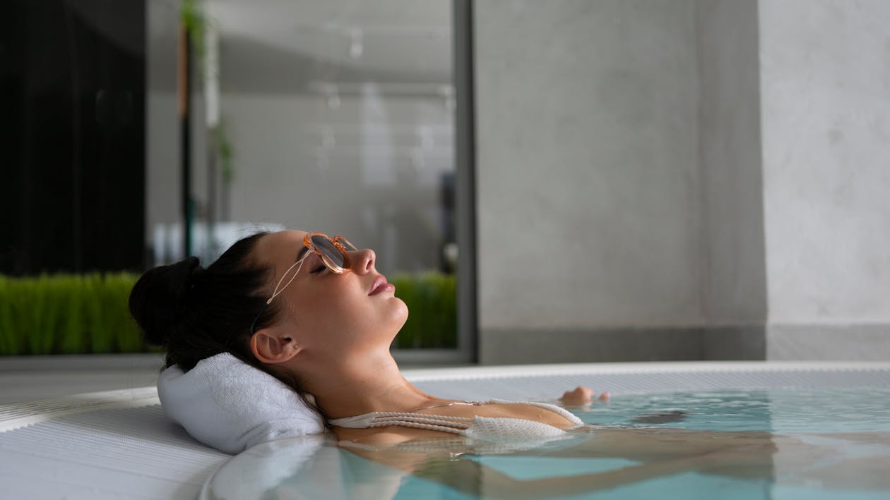 A Woman with Sunglasses Relaxing in a Jacuzzi