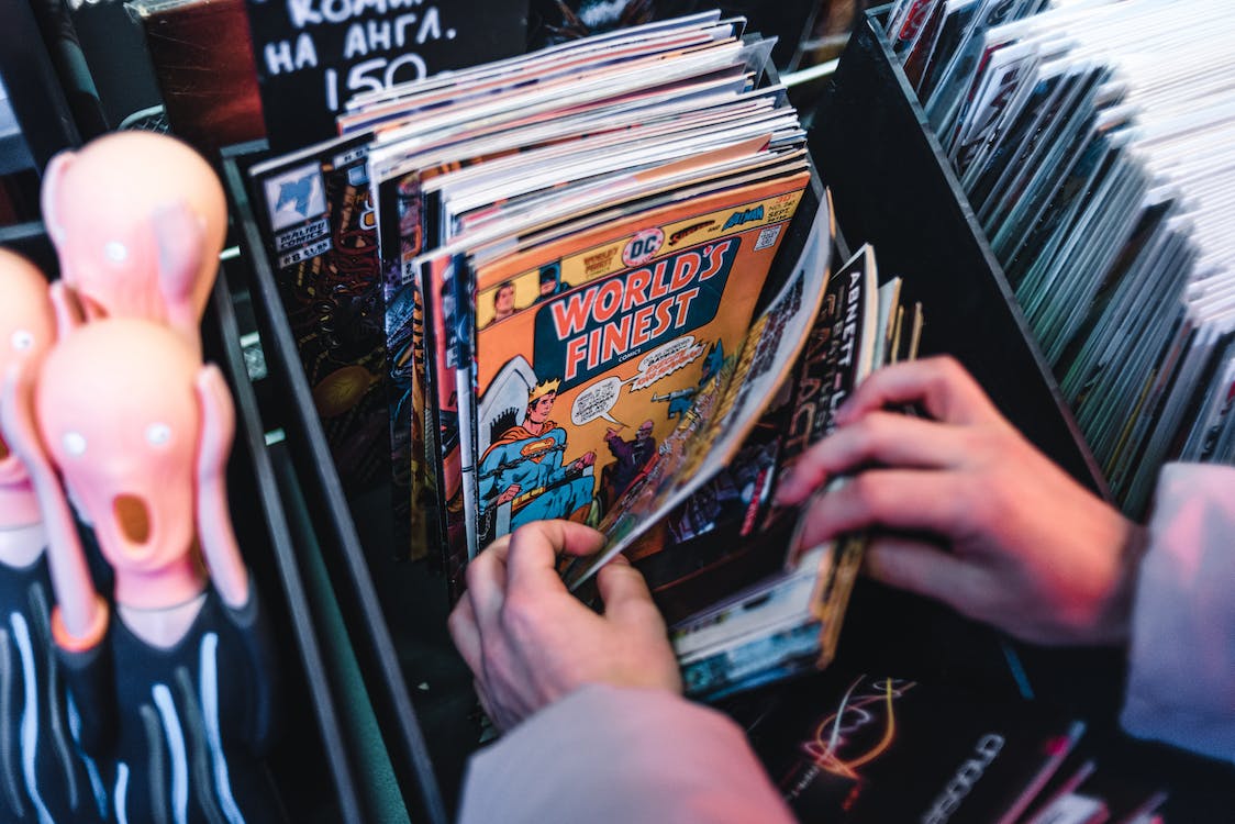 Close-Up Shot of a Person Holding Comic Books