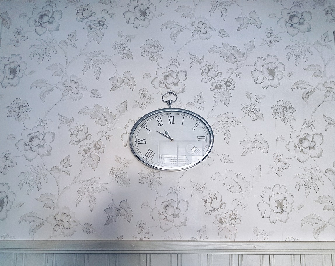 toile wallpaper with a wall clock
